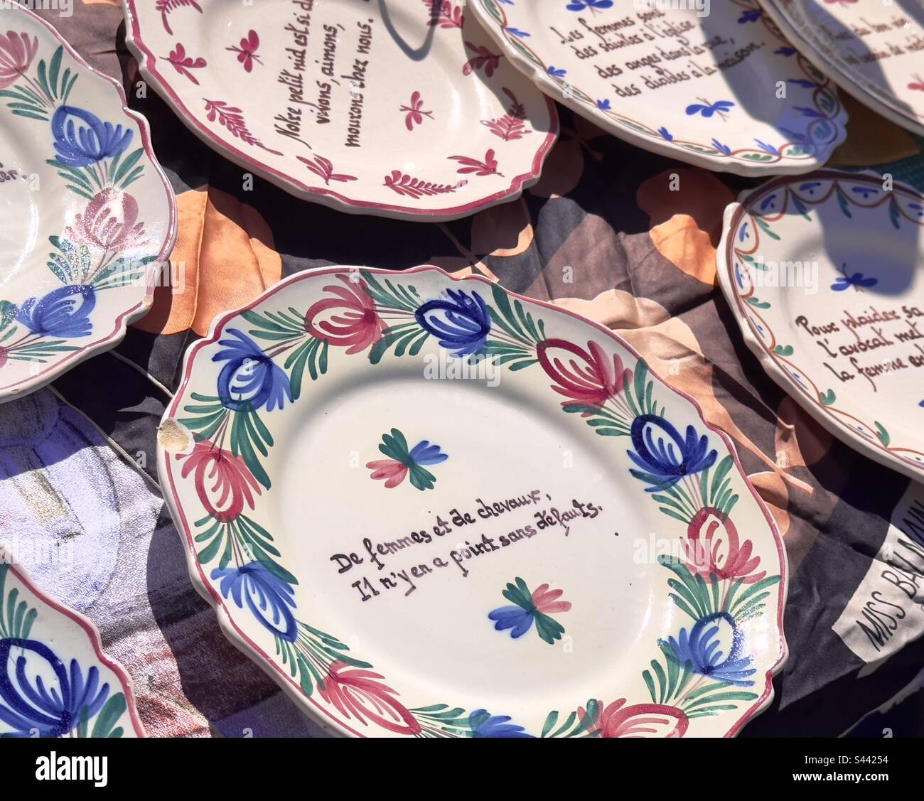 Cena francese, piatti dal design tradizionale con mottos e bon mots in vendita in un mercato di antiquariato francese Foto Stock