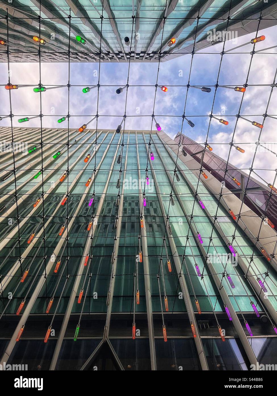 Luci colorate in una corda che si stringe attraverso le alte torri in Sir Simon Milton Square a Victoria, Londra SW1 - opere d'arte pubbliche Foto Stock