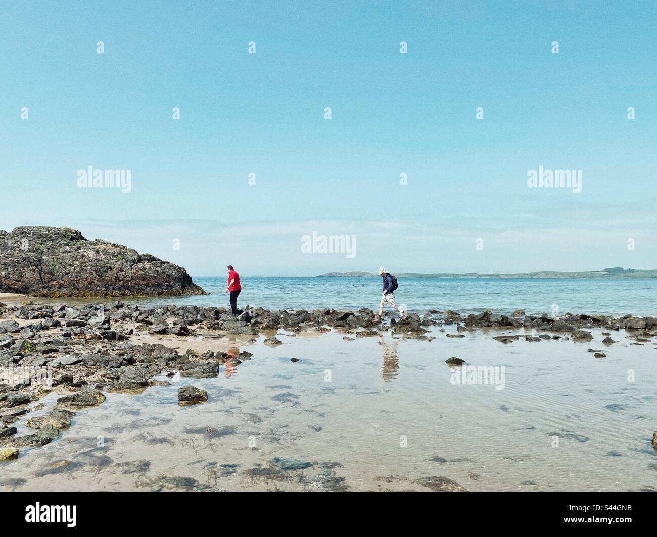 Persone che attraversano la spiaggia di Newborough per l'isola di Llandwyn prima della bassa marea, Anglesey, Galles del Nord Foto Stock