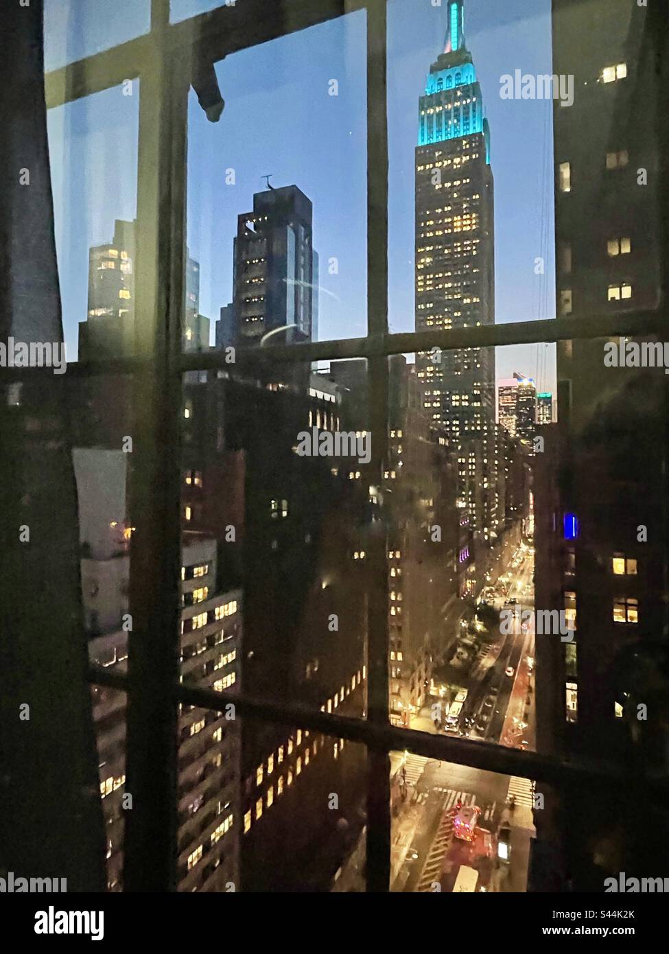 Guarda una finestra dell'appartamento di Manhattan verso l'Empire StateBuilding - Immagine stock catturata con smartphone