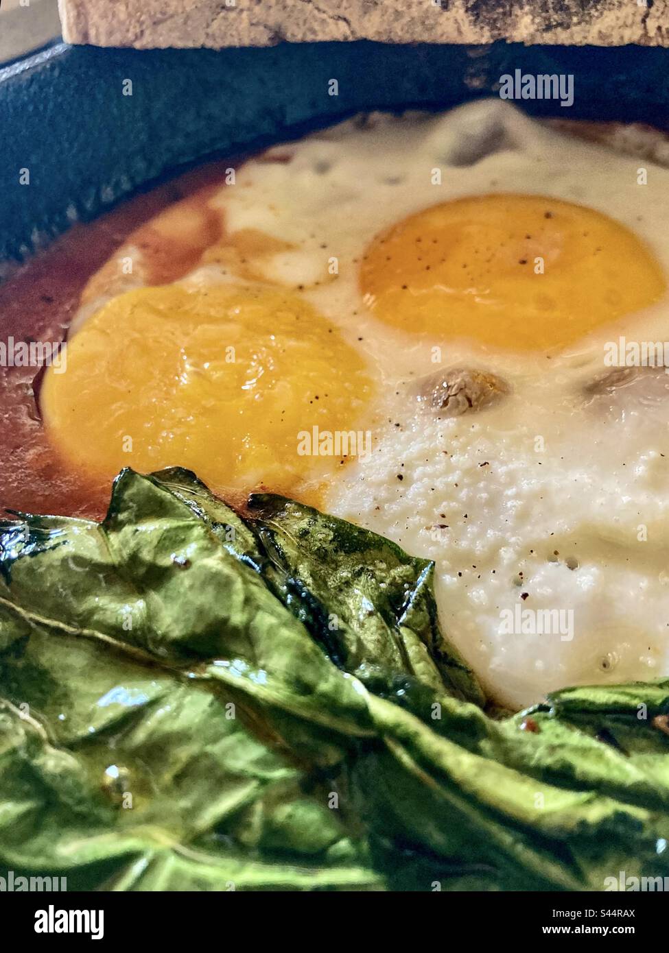 Uova e verdi su un letto di fagioli. Foto Stock