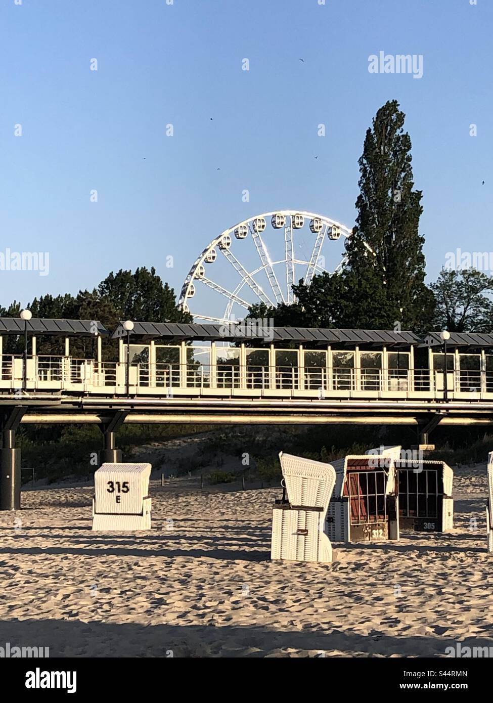 Parte della Seebrücke di Heringsdorf, sedie a sdraio e una grande ruota sul retro Foto Stock