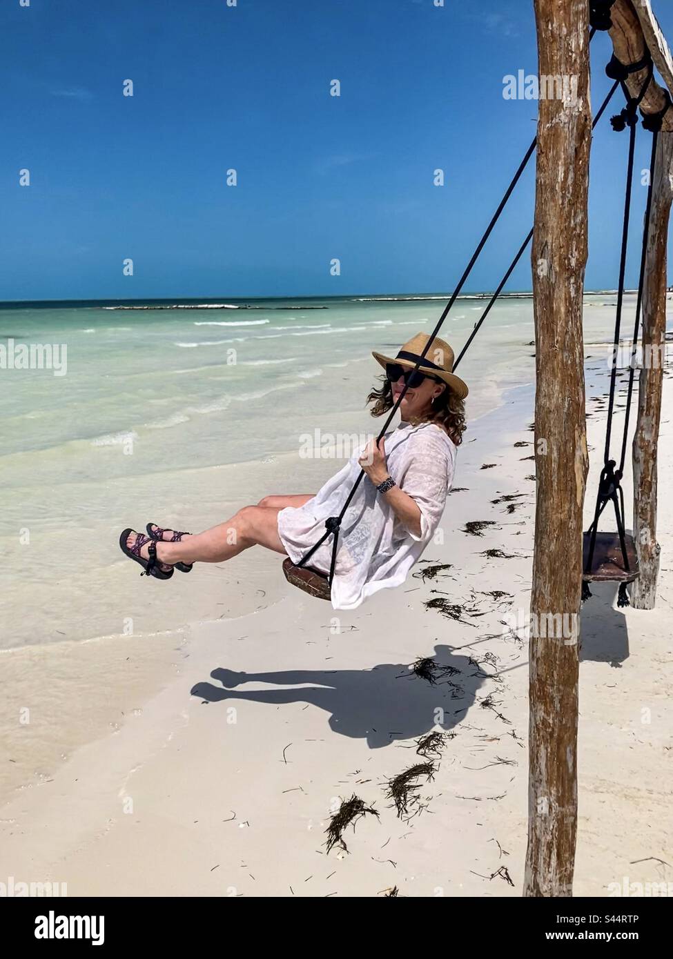 Una bella donna oscilla su una bellissima spiaggia. Foto Stock