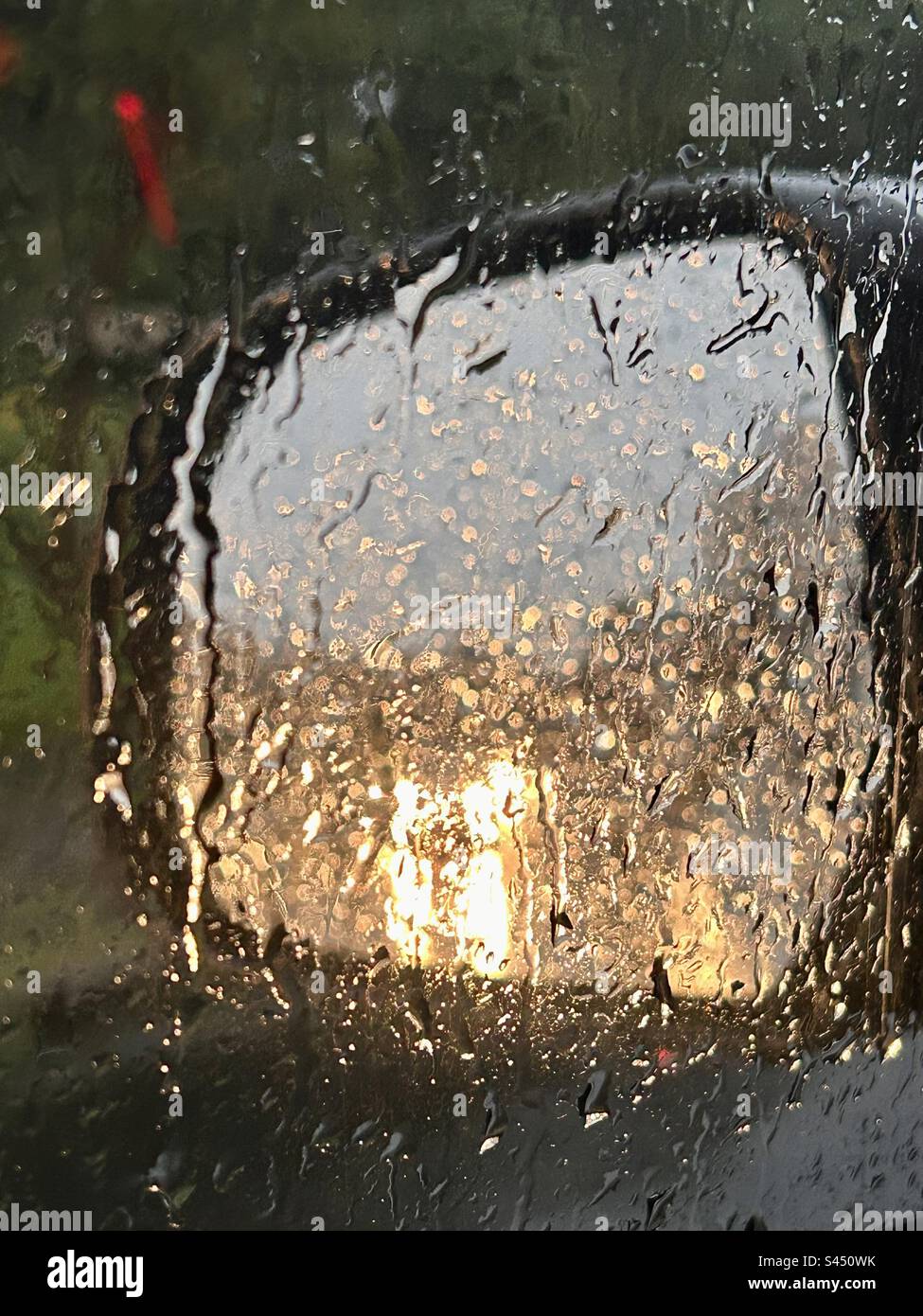 riflessi di una giornata piovosa attraverso uno specchietto retrovisore Foto Stock