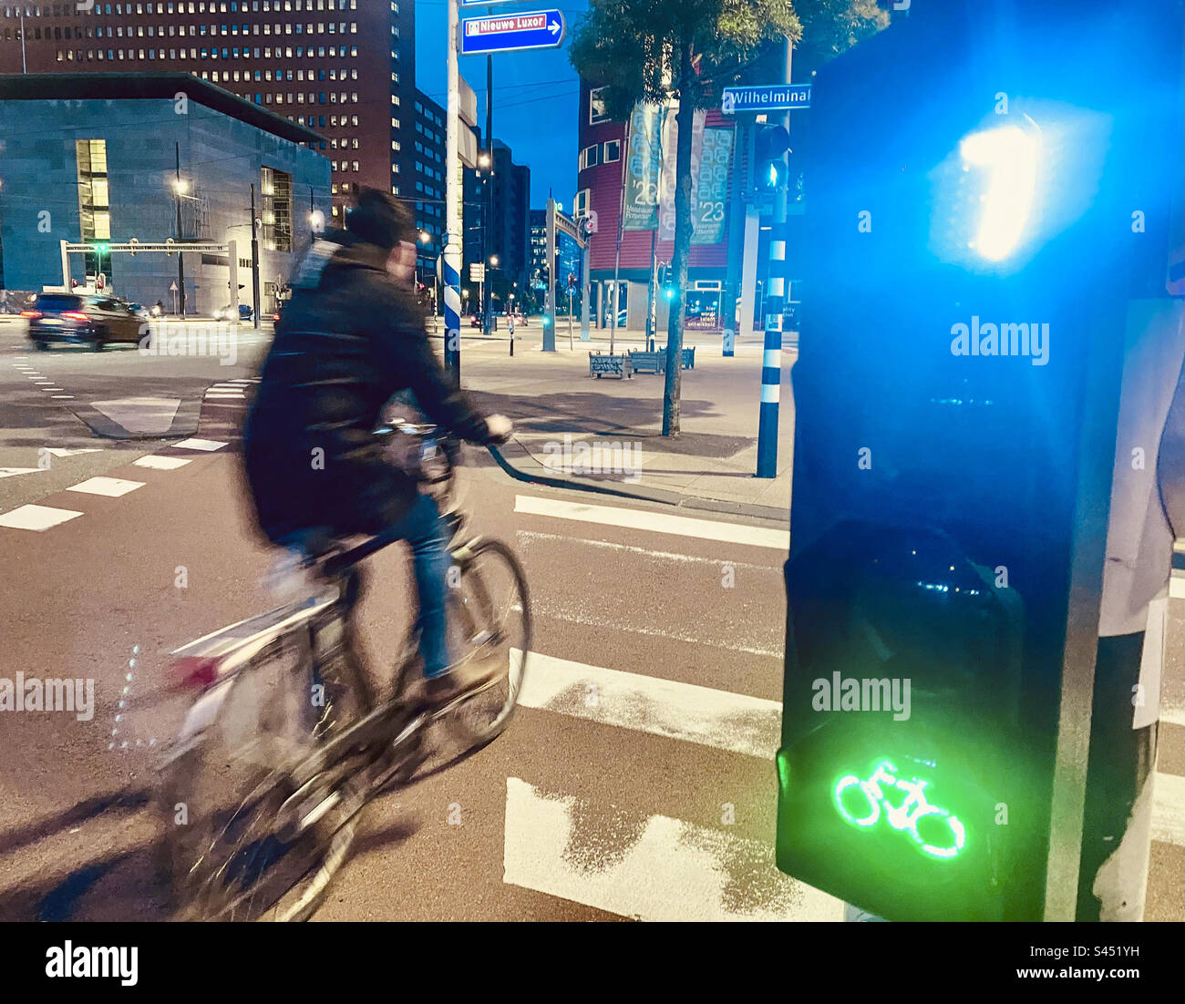 Un ciclista passa attraverso un semaforo verde a Rotterdam Foto Stock