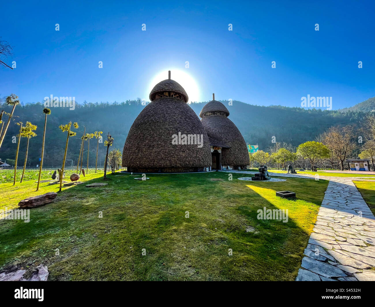 Sole dietro una capanna del villaggio Foto Stock