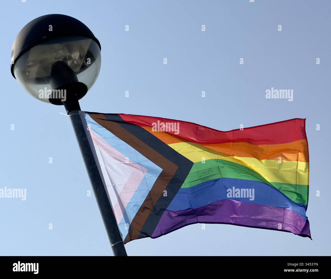 La bandiera multicolore dell'inclusività che sventola da un lampione in un supermercato Worcester. Foto Stock