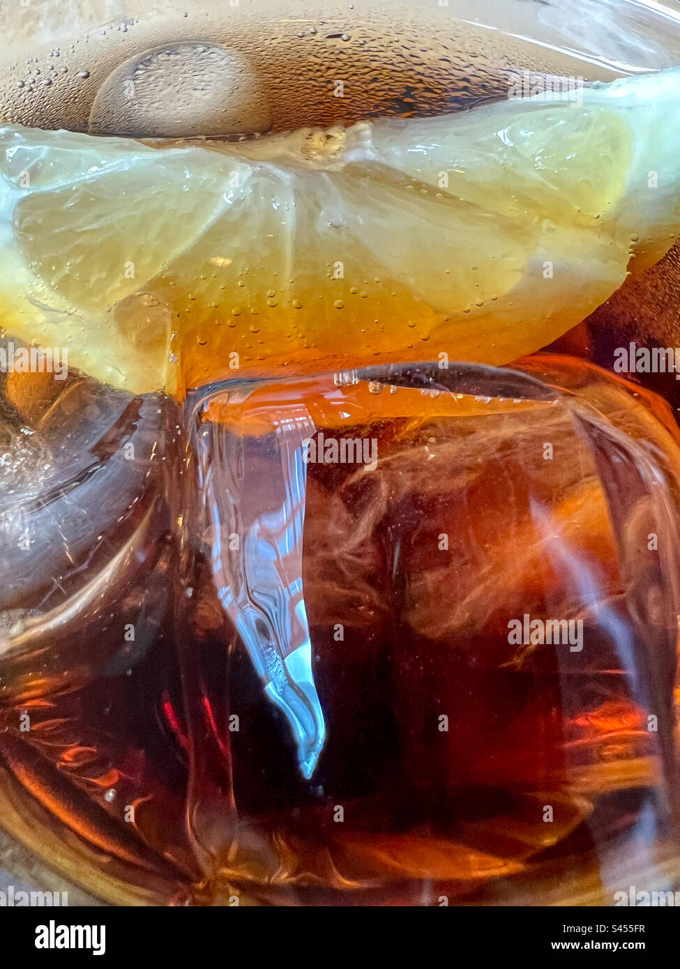 Cubetti di ghiaccio e limone in un bicchiere di Ice cola fredda Foto Stock
