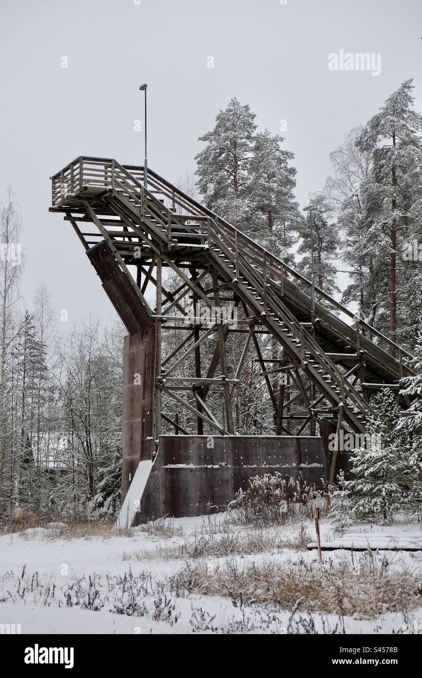 Allenatevi con gli sci in legno, saltando in mezzo al paesaggio innevato della foresta invernale - Immagine stock catturata con smartphone