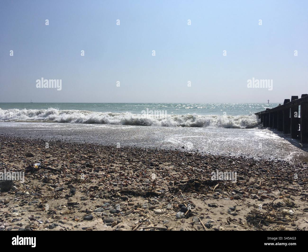 Onde che si infrangono e mare scintillante a Worthing Beach Foto Stock
