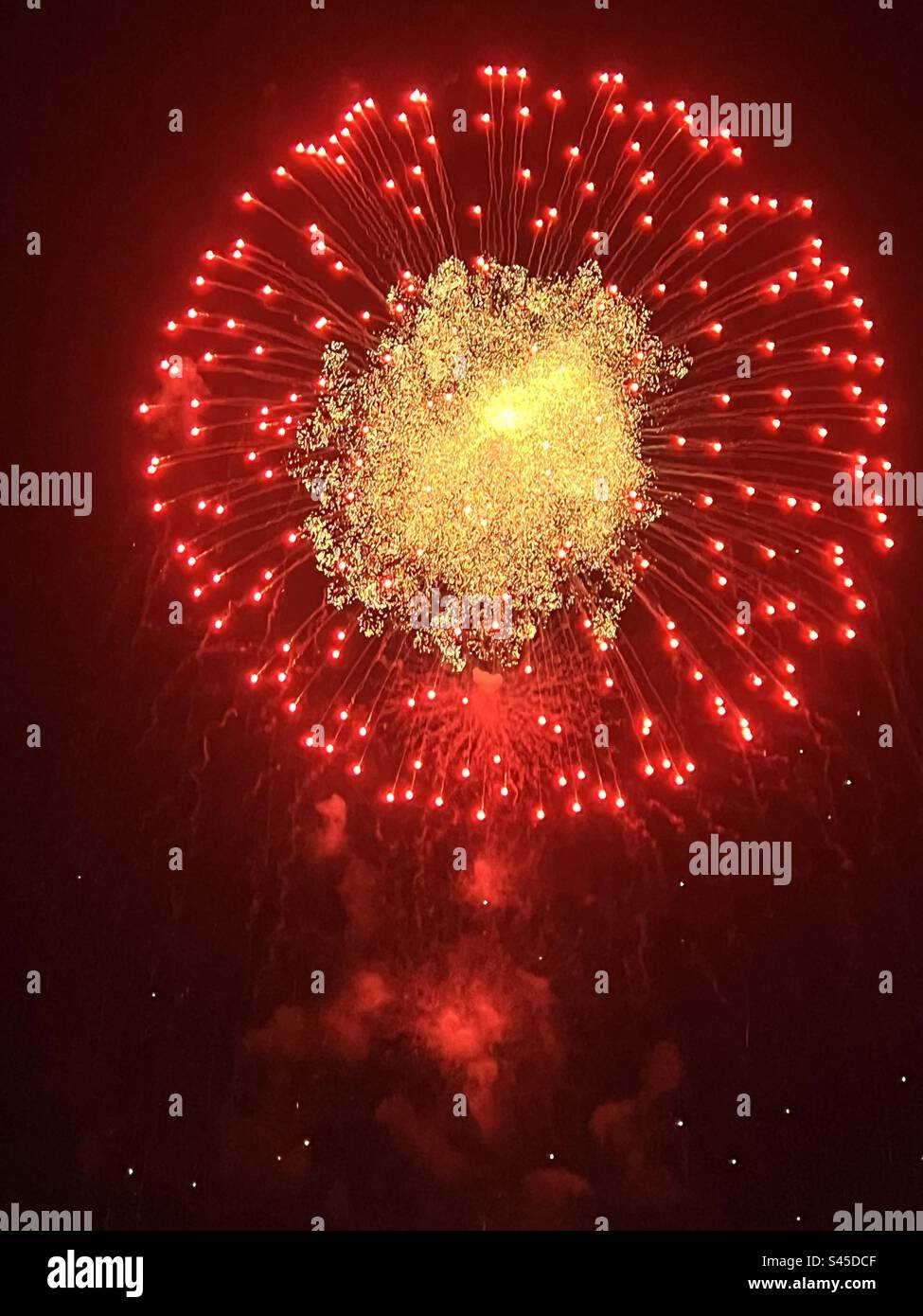 Fuochi d'artificio aerei rossi con centro denso d'oro Foto Stock