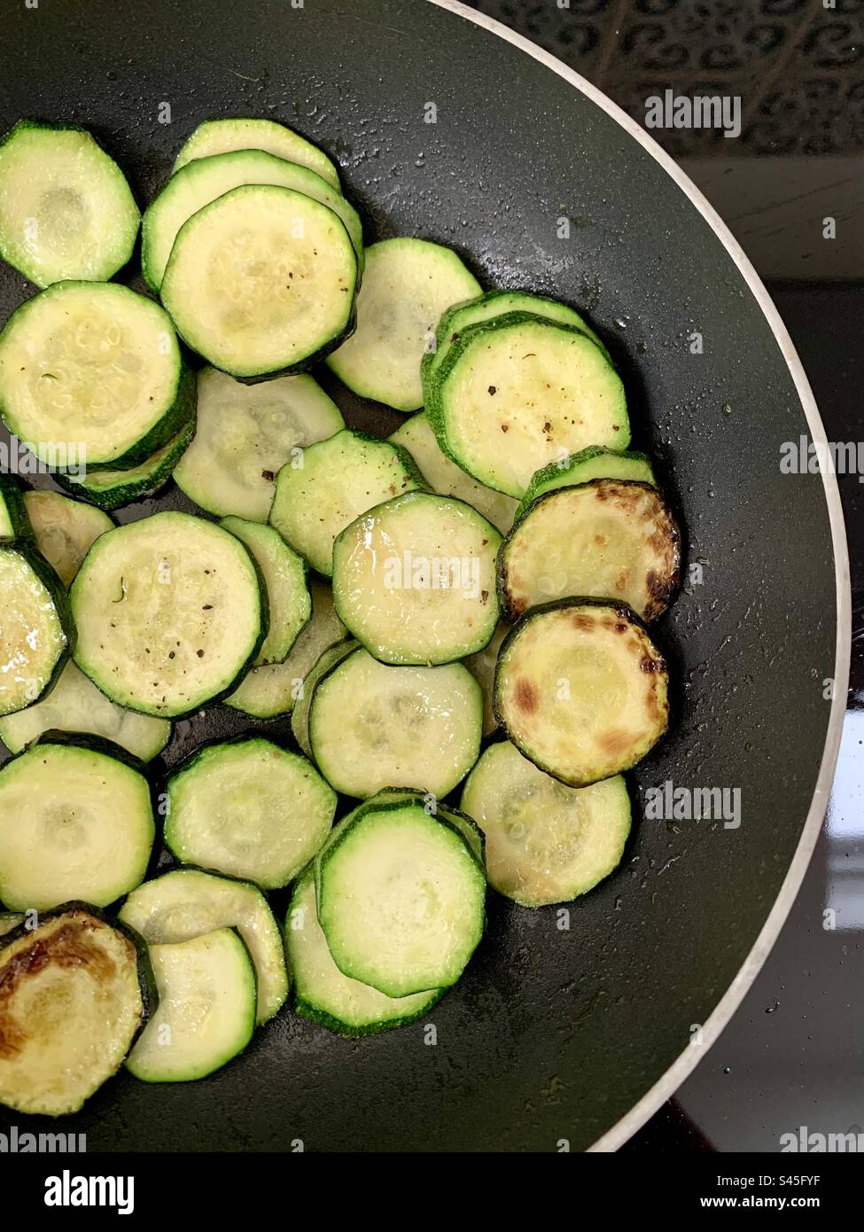 Zucchine a fette che friggono in padella Foto Stock