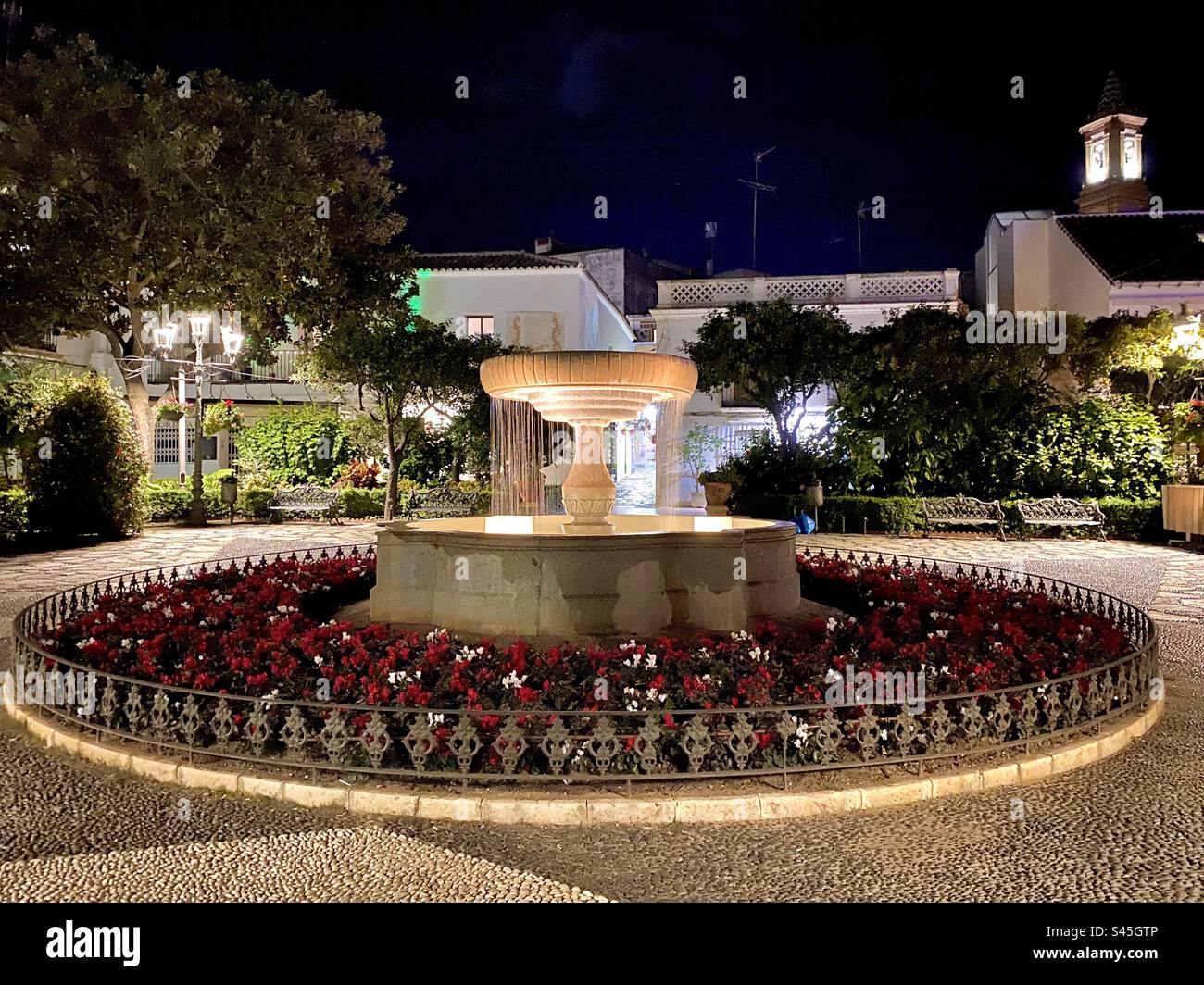 La fontana illuminata di notte a plaza del flores a Estepona, nel sud della Spagna Foto Stock