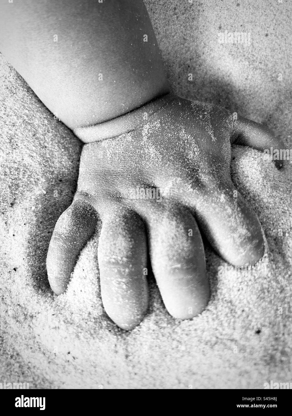 esperienza con la sabbia: mano del bambino Foto Stock