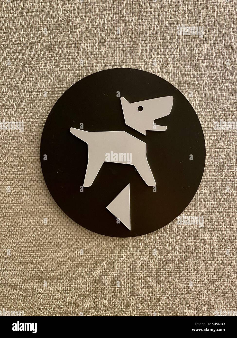 Un cartello dell'hotel carino indicante la direzione dell'area pedonale per i cani. Foto Stock