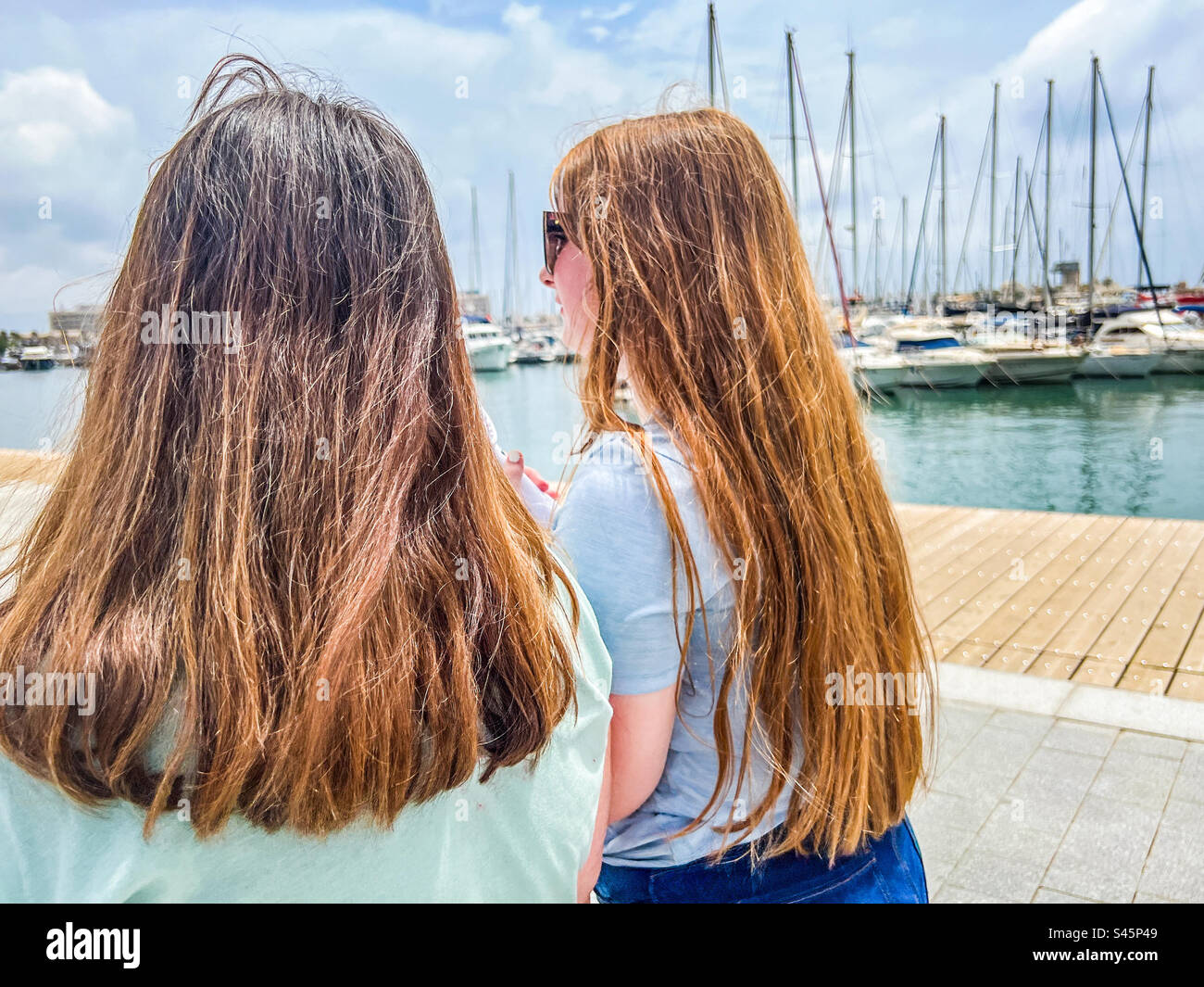 Due giovani donne che camminano nel porto di Alicante in Spagna Foto Stock