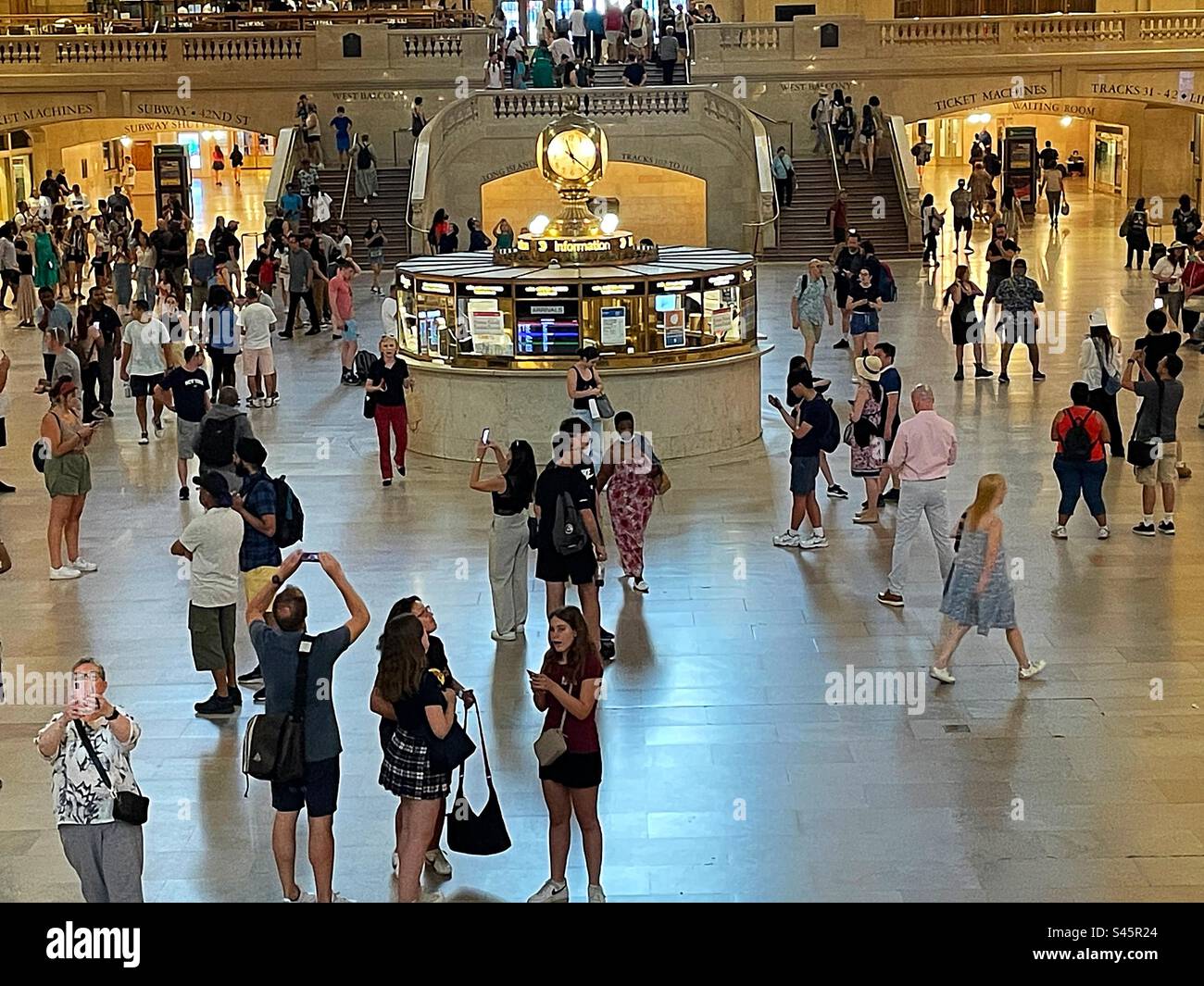 Il chiosco informativo con un enorme orologio a quattro lati decorato è il punto focale del Grand Concourse nel terminal Grand Central, 2023, New York City, USA - Immagine stock catturata con smartphone