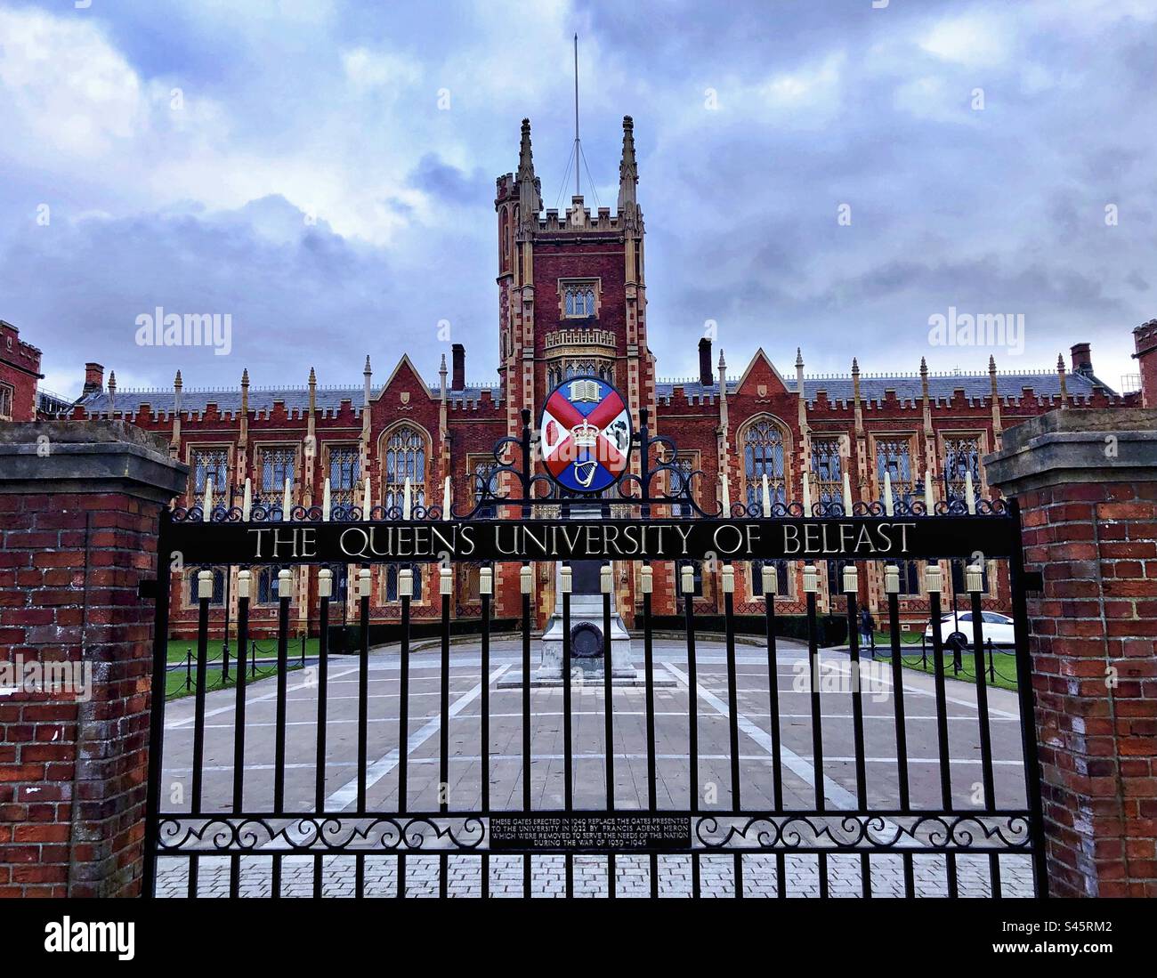 Queens University Belfast mostra i cancelli d'ingresso con lo stemma Foto Stock