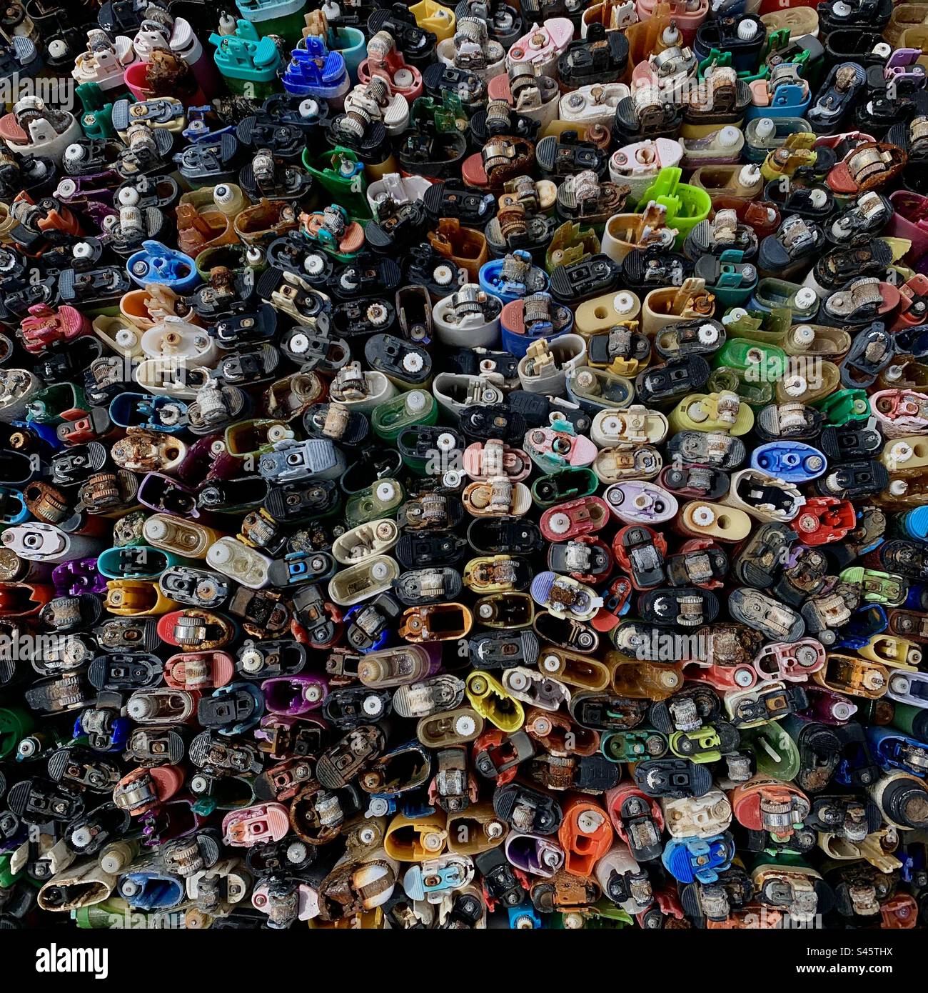 Una raccolta di accendini di plastica rifiuti di spiaggia - inquinamento di plastica - Immagine stock catturata con smartphone