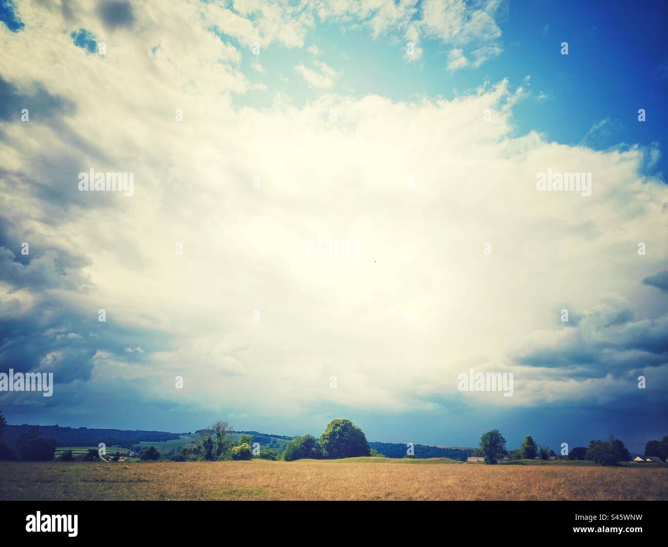 Una fotografia del cielo sopra la brughiera comune. Grandi nuvole bianche, perfetto paesaggio dello spazio di copia. Orizzonte basso e cielo lungoso. - Immagine stock catturata con smartphone
