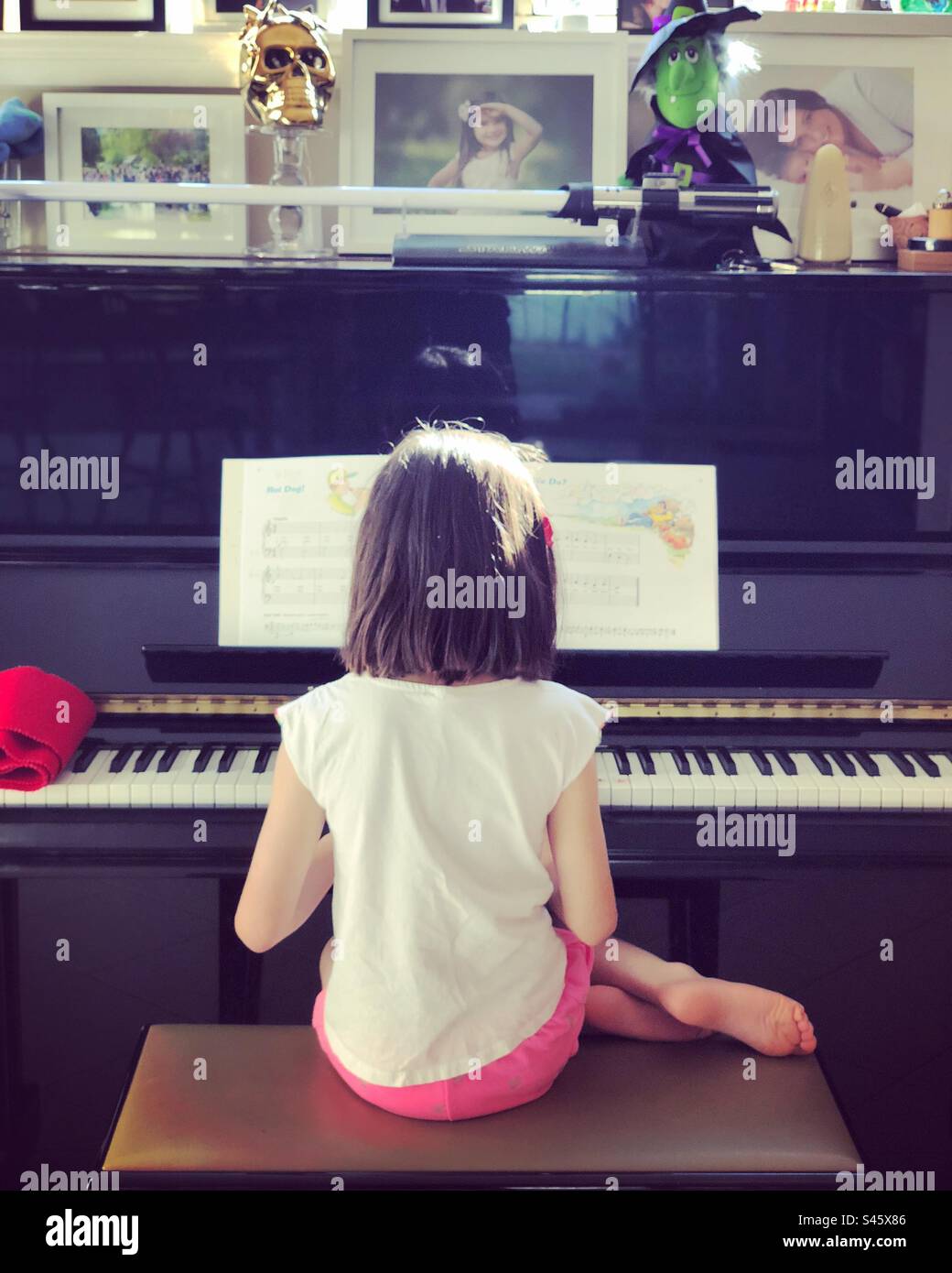 Una ragazza suonare il pianoforte Foto Stock