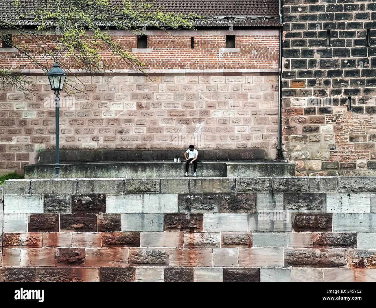 Piccola silhouette umana davanti allo sfondo del muro di mattoni - Immagine stock catturata con smartphone