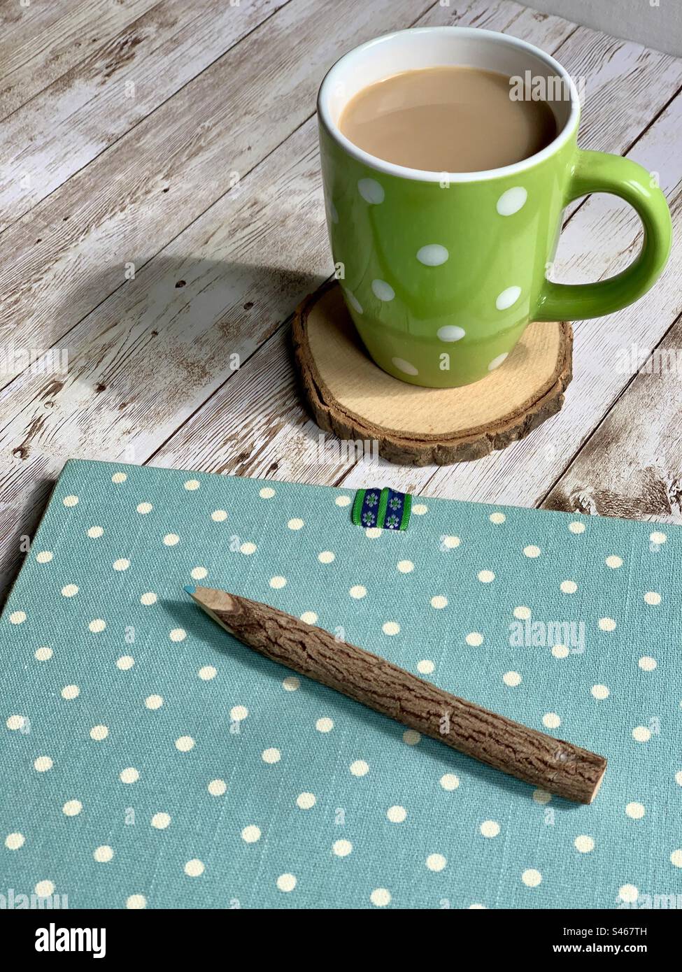Blocco note a pois blu e bianco, matita a ramoscello e caffè in una tazza a pois - Immagine stock catturata con smartphone