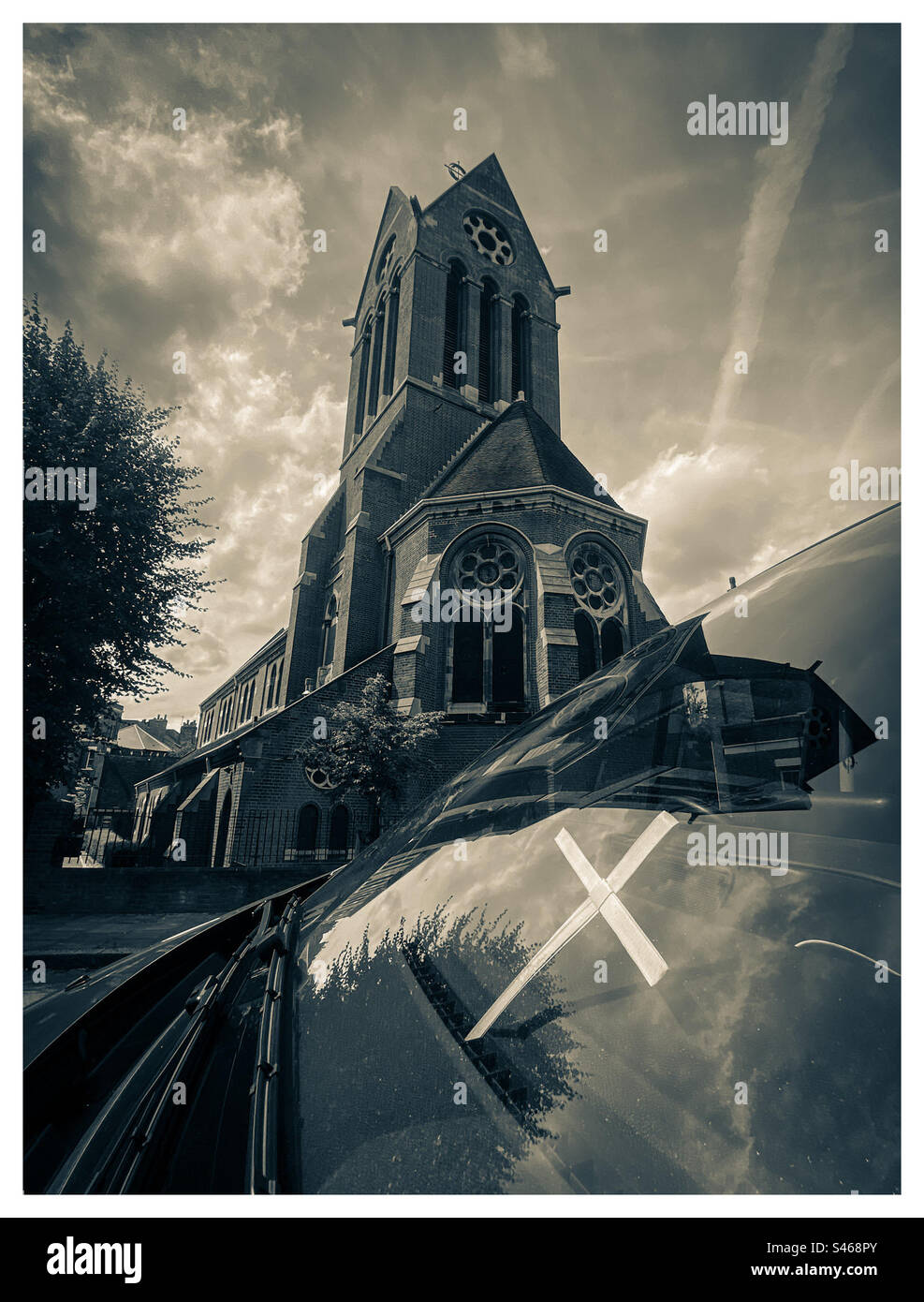 Una croce nella finestra di un pulmino di fronte alla chiesa di St Lukes a Londra - Immagine stock catturata con smartphone