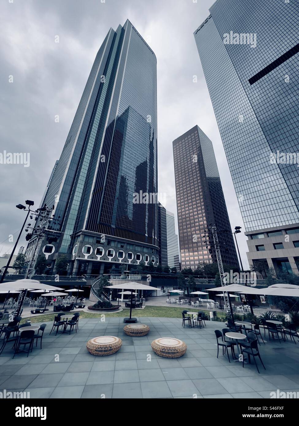 LOS ANGELES, CA, DEC 2022: Immagine verticale di tavoli e sedie allestita il giorno di proiezione al California Plaza nel Downtown Financial District, i grattacieli raggiungono il cielo sullo sfondo - Immagine stock catturata con smartphone