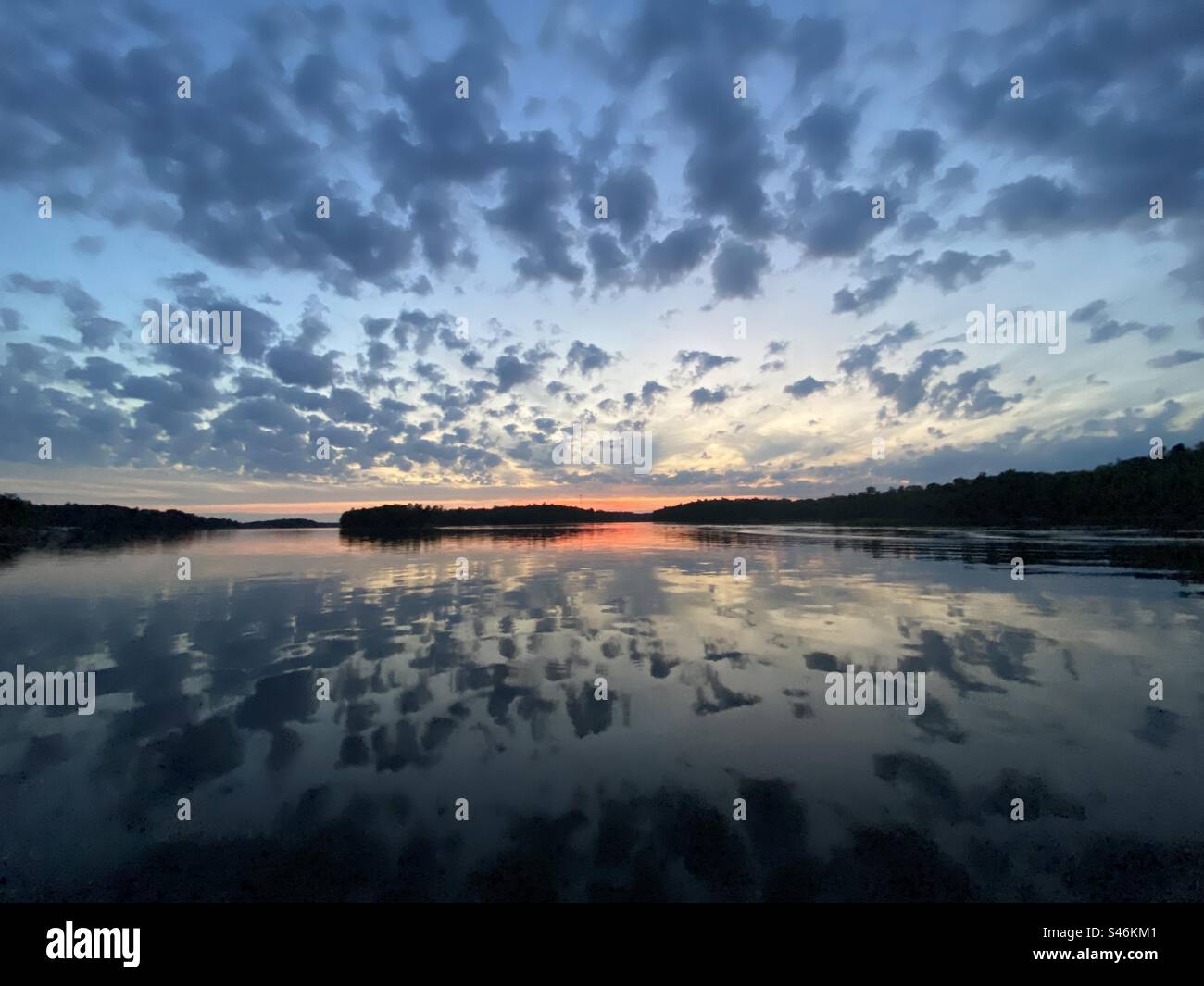 Cielo grandangolare che si riflette sul lago dopo il tramonto Foto Stock