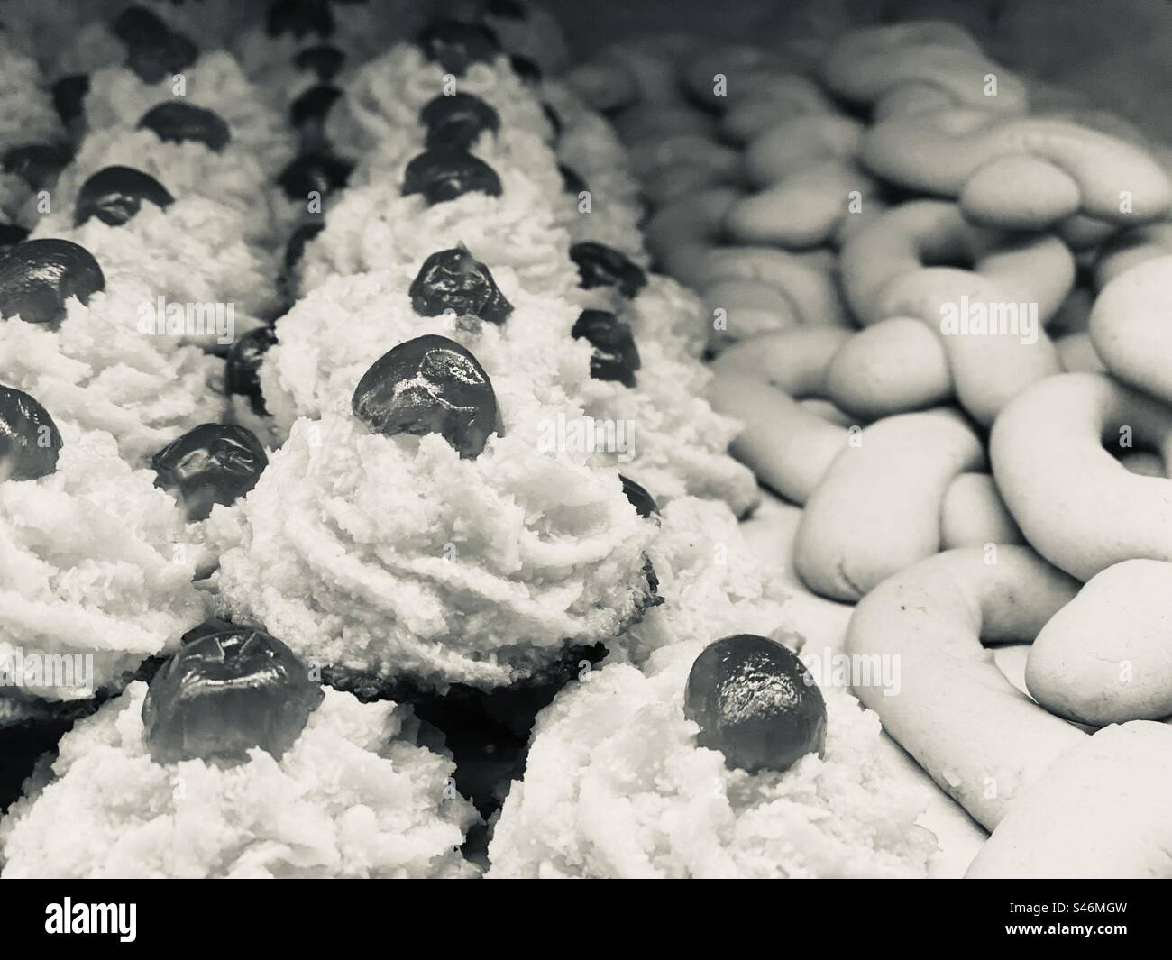 Dolci tipici portoghesi preparati con farina, cocco e ciliegie, in un forno. L'Algarve, Portogallo. - Immagine stock catturata con smartphone