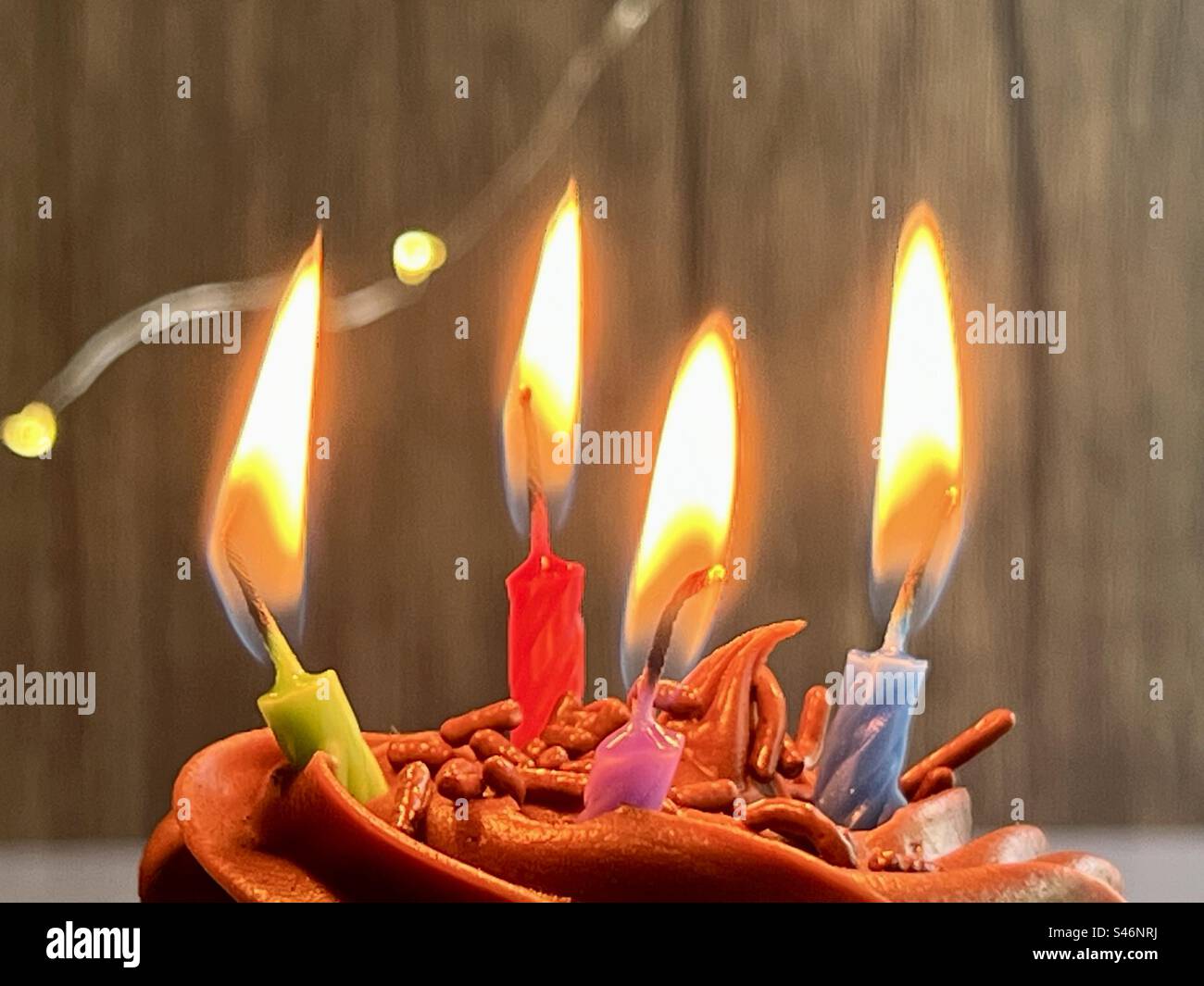 Cupcake al cioccolato con quattro candele di compleanno Foto Stock