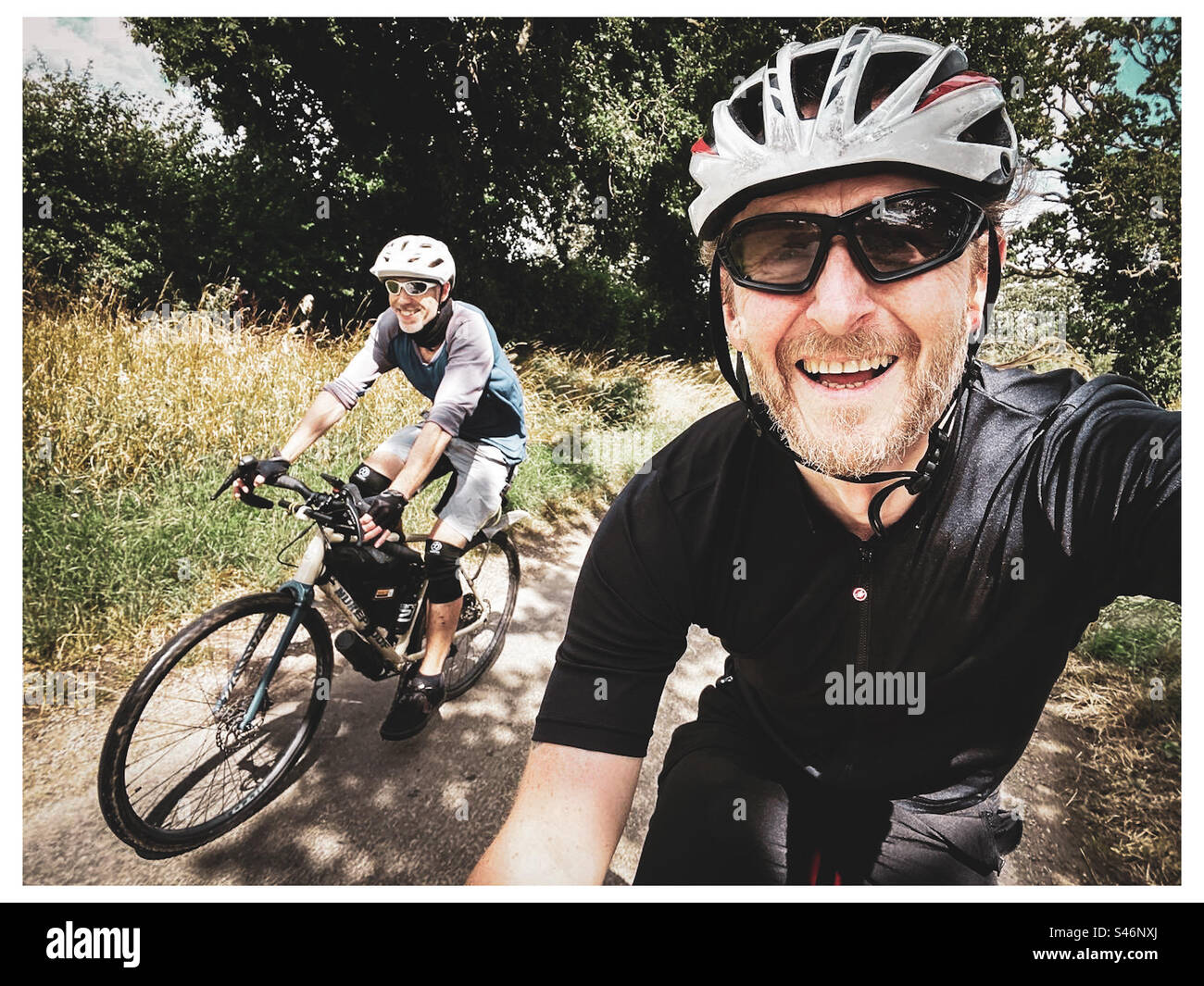 Due amici potranno fare un viaggio in bicicletta con il bel tempo a Norfolk, Regno Unito, in estate Foto Stock