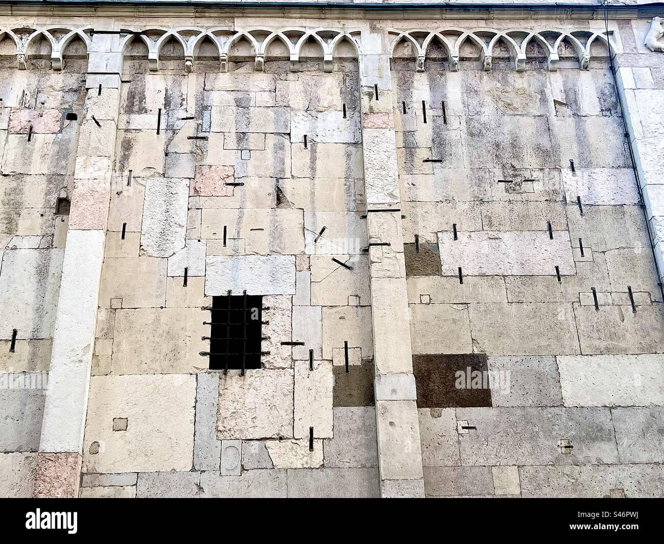 Primo piano di una cattedrale con molti graffi metallici all'esterno da riparazioni, contribuendo a mantenere le pietre al sicuro Foto Stock