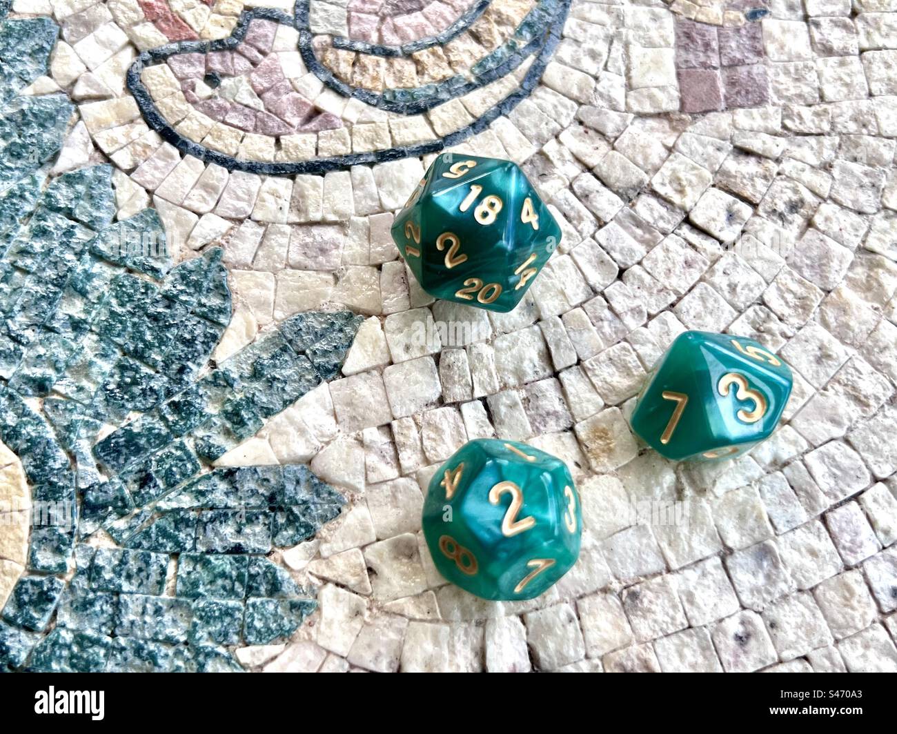 Dadi da gioco di ruolo - 3 dadi verdi incluso d20 su un tavolo a mosaico Foto Stock