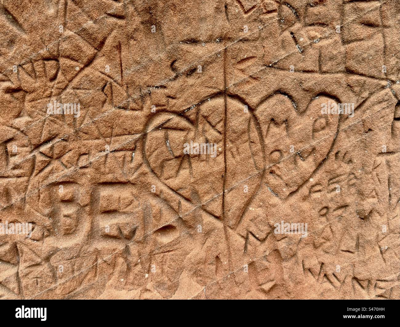 Graffiti di cuori collegati graffiati nella pietra arenaria rossa di Kinver nello Staffordshire Foto Stock