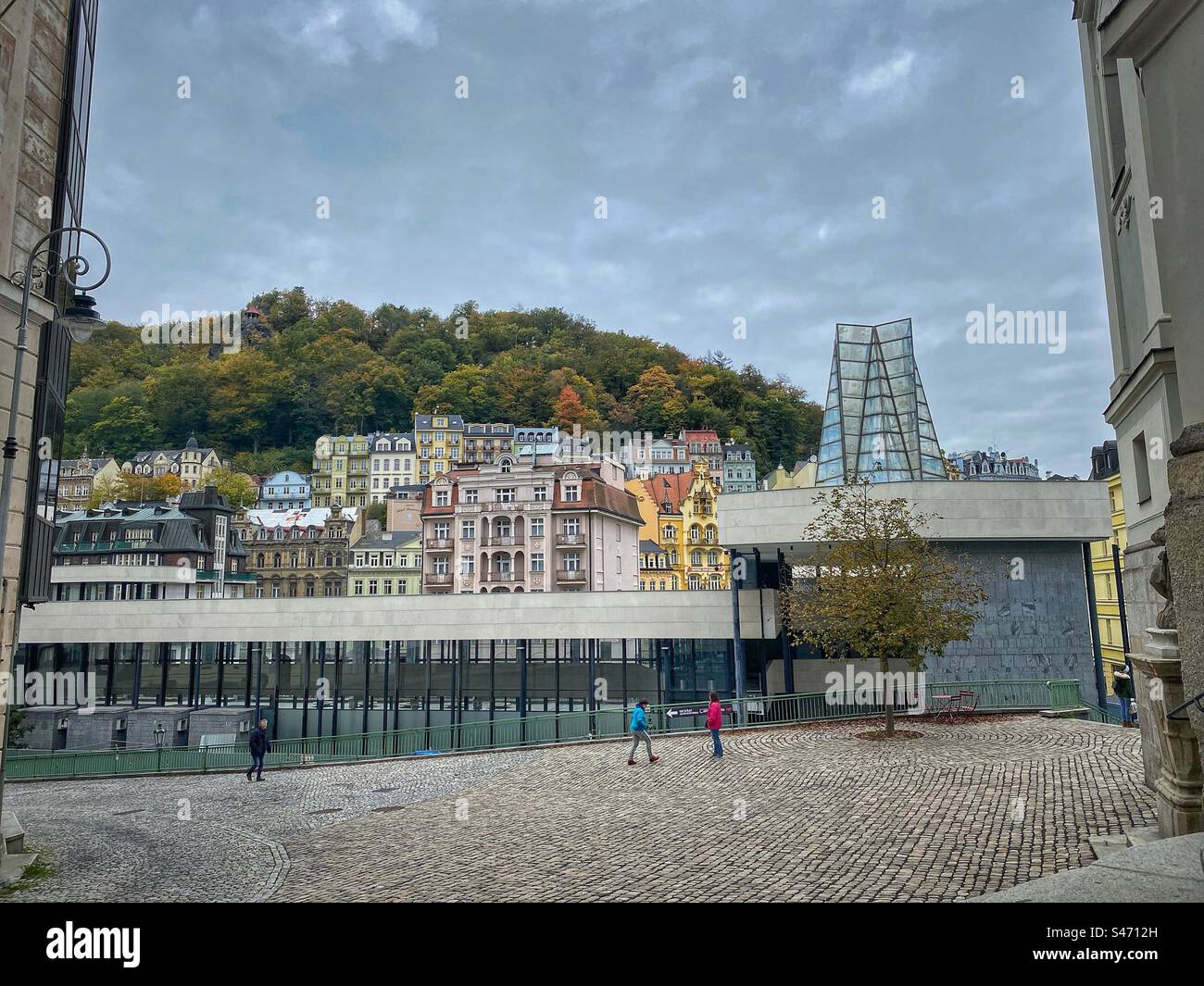 Colonnato delle sorgenti termali calde (Vridlo) costruito in stile funzionale e con antichi edifici storici colorati a Karlovy Vary, Repubblica Ceca. Foto Stock
