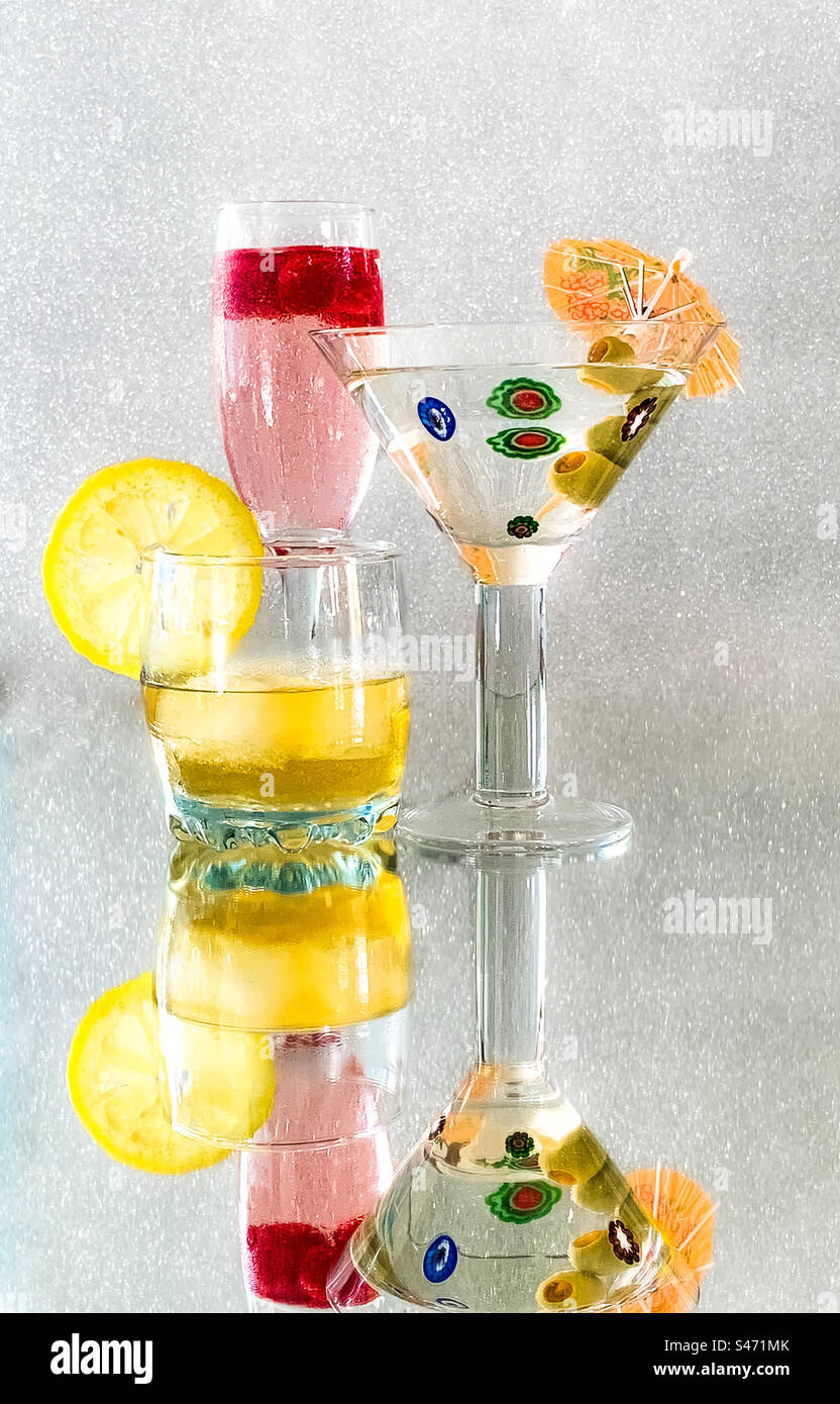 Bevande alcoliche su una superficie riflettente con sfondo scintillante Foto Stock