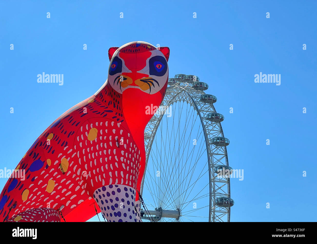 Gatto gonfiabile di fronte al National Theatre sulla London South Bank con il London Eye sullo sfondo su un cielo blu brillante Foto Stock