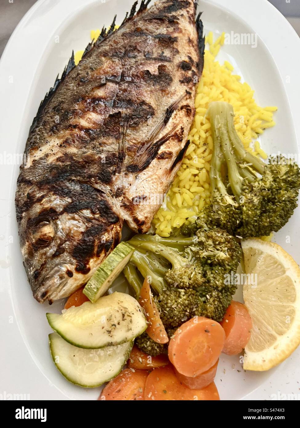 Una sana cena mediterranea a base di pesce, riso e verdure. - Immagine stock catturata con smartphone