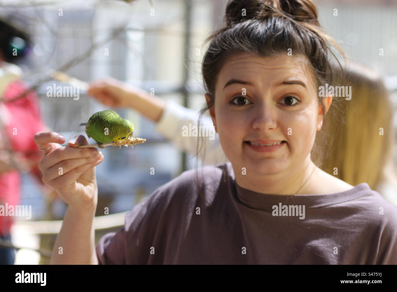 Una giovane donna nervosa che tiene un uccello su un bastone Foto Stock