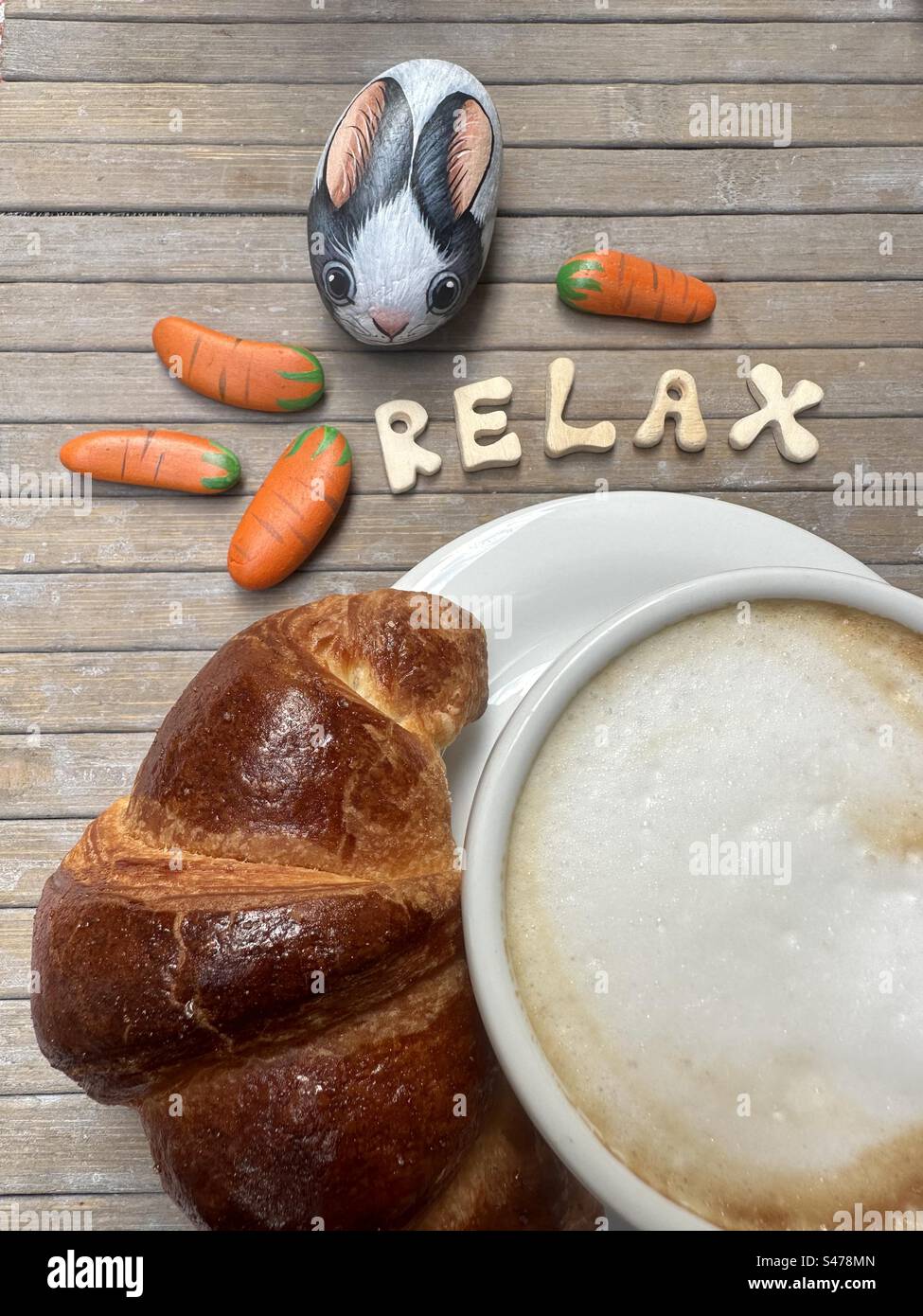 La mattina rilassati con una colazione dolce e un coniglio dipinto di pietra Foto Stock