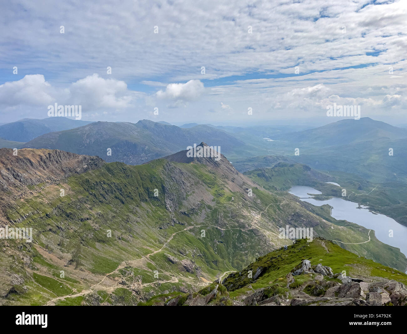 Vista dalla cima del monte Yr Wyddfa (Snowdon) più alto del Galles, che mostra i sentieri di Crib Goch, Pyg e Miners, Gwynedd, Galles Foto Stock