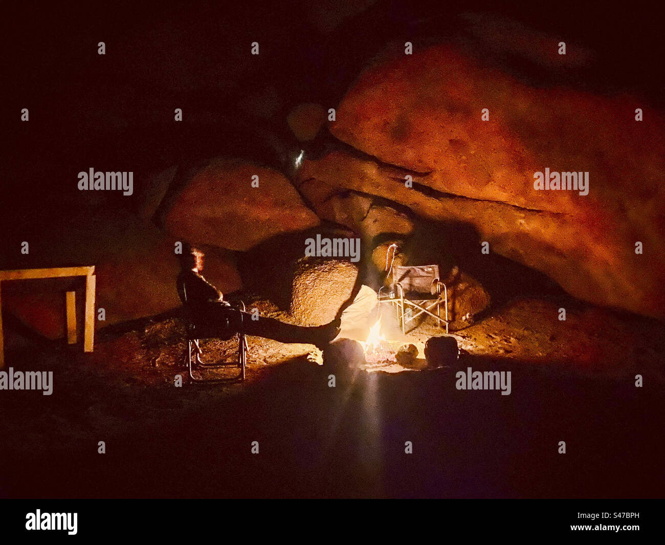 Una persona si rilassa davanti a un falò di notte nella regione di Erongo in Namibia - Immagine stock catturata con smartphone