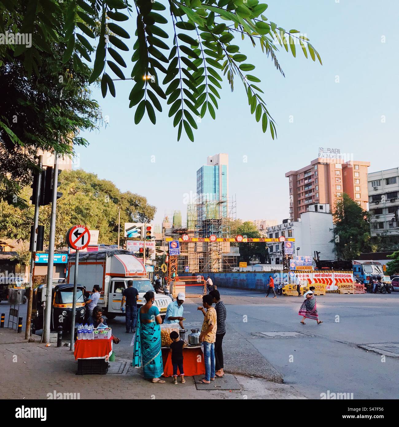 Costruzione della metropolitana a Mumbai, India, con venditori di cibo di strada in primo piano Foto Stock