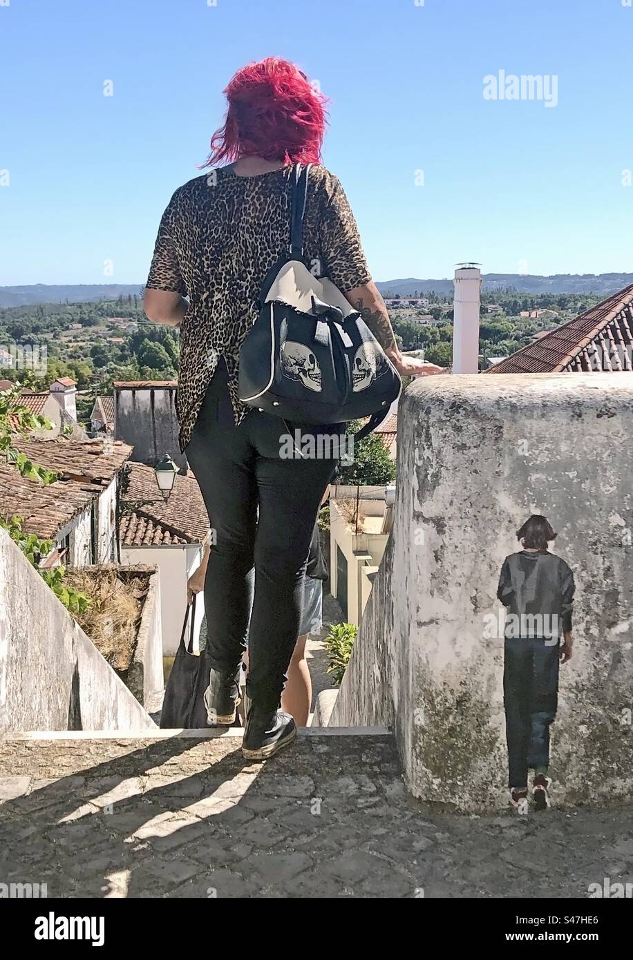 Gente che cammina accanto al murale di un uomo piccolo - Immagine stock catturata con smartphone