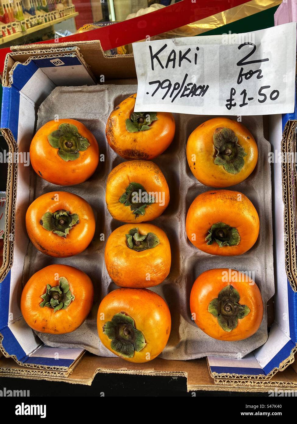 Kaki o Persimmon hanno un prezzo in vendita al Grocers Shop - Immagine stock catturata con smartphone