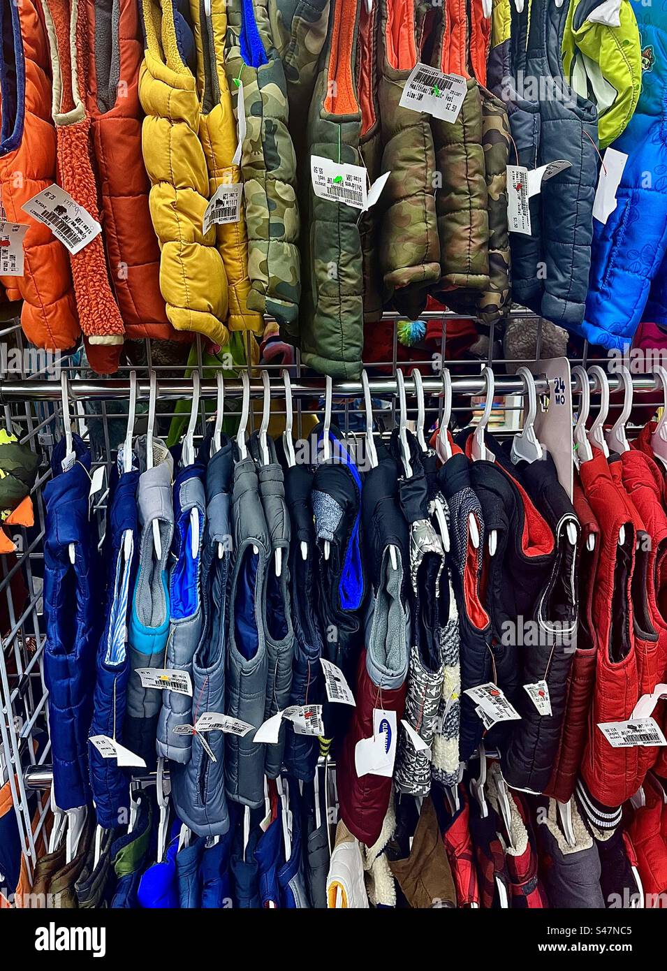 2 rack di giubbotti invernali per bambini in vendita - Immagine stock catturata con smartphone