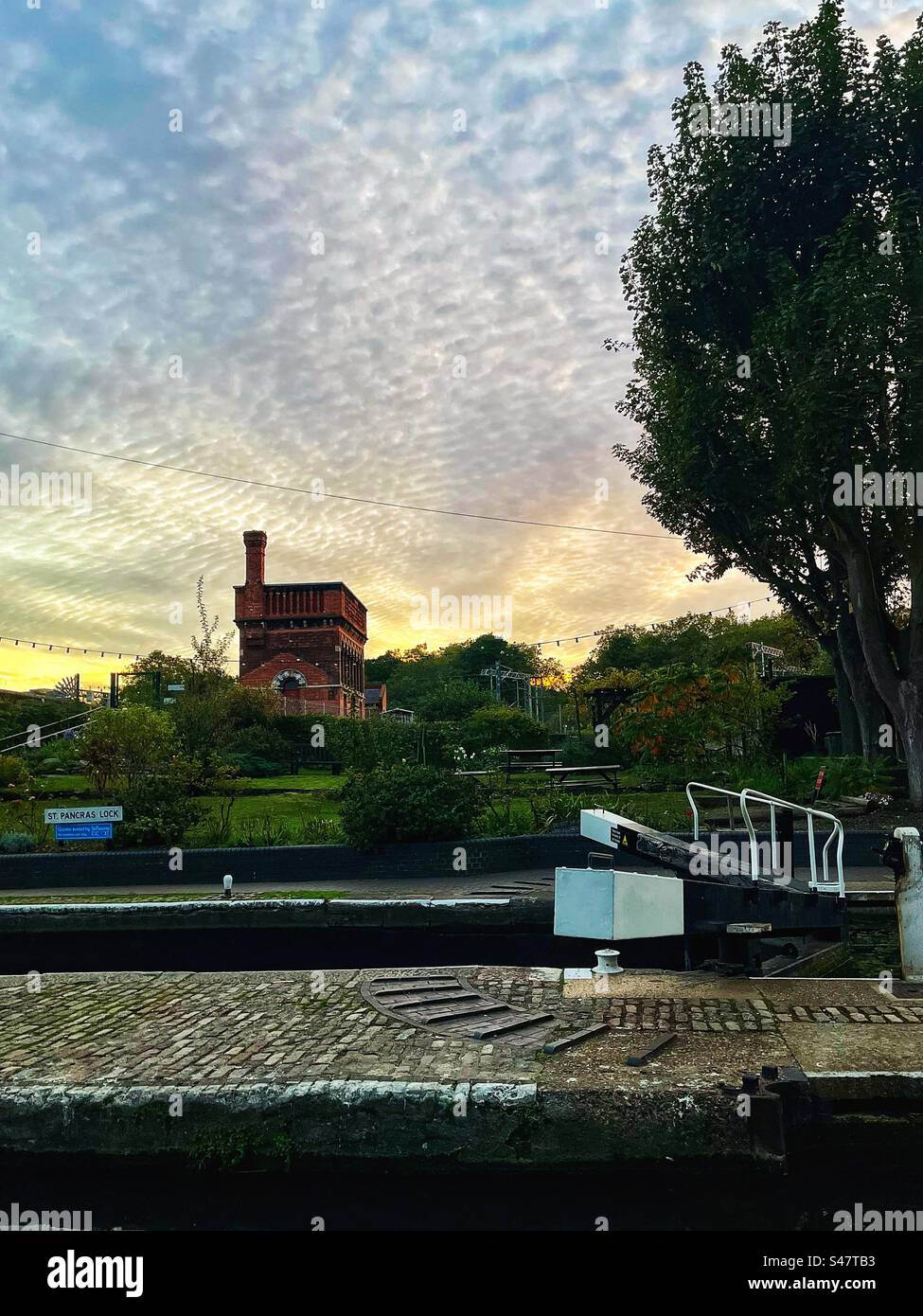 Porte chiuse sul Regents Canal e l'eccentrico edificio Waterpoint sullo sfondo costruito per servire i primi treni a vapore in St. Stazione di Pancras nel 1868 - Londra - Immagine stock catturata con smartphone