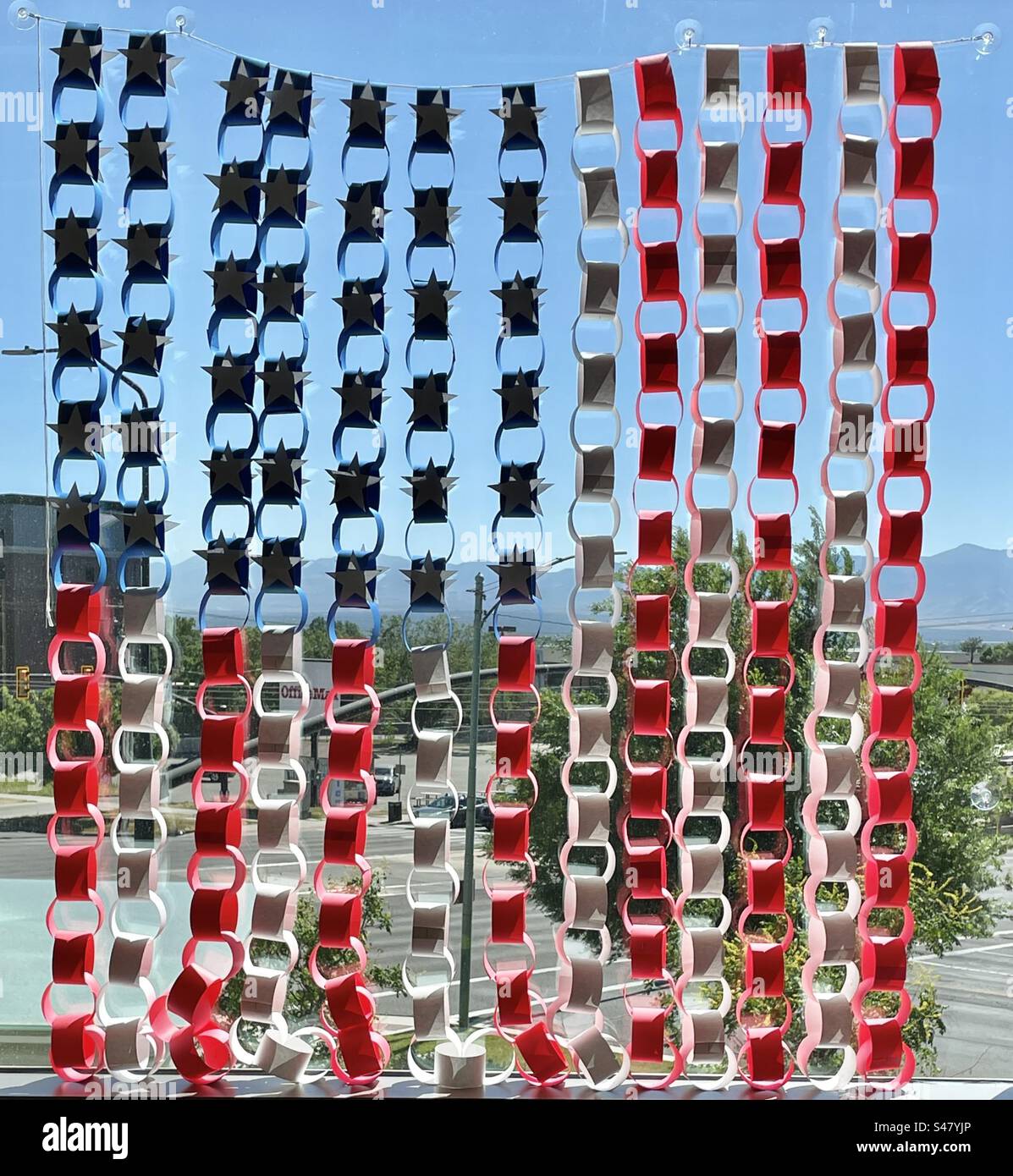 Catene di carta da costruzione di rosso, bianco e blu fanno la bandiera americana, dando a questa finestra ospedale un po' di patriottismo e colore. - Immagine stock catturata con smartphone
